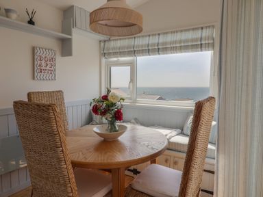 A dining room with a table and chairs at Salt & Stone Lyme Regis