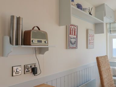 A kitchen with a radio and wall art at Salt & Stone in Lyme Regis