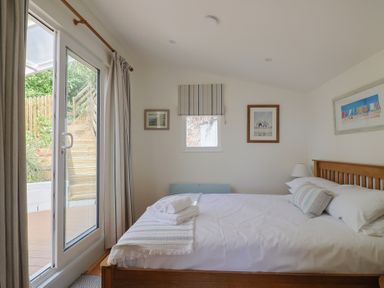 A bedroom with a bed and window at Salt & Stone in Lyme Regis