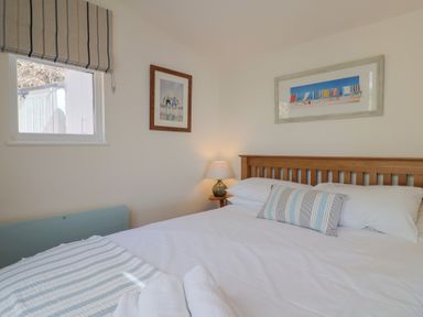 A bedroom with a bed and window at Salt & Stone Lyme Regis
