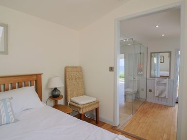 A bedroom with a bed and adjoining bathroom at Salt & Stone in Lyme Regis