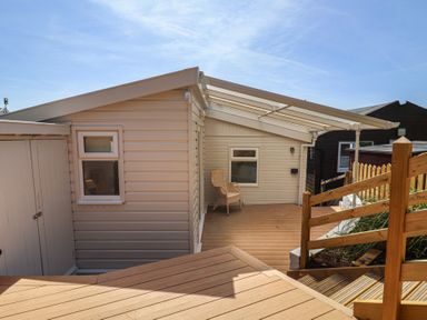 An outdoor area with a chair and shed at Salt & Stone in Lyme Regis