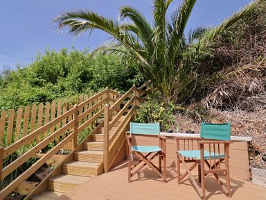 Two wooden chairs and a table beside stairs at Salt &amp; Stone in Lyme Regis