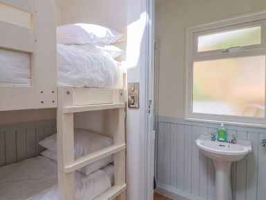 A bedroom with bunk beds and a sink at Salt & Stone Lyme Regis