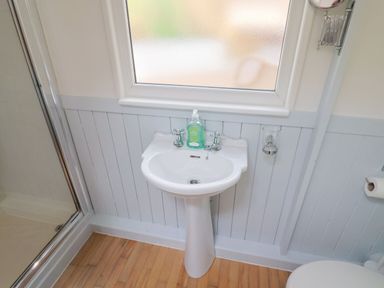 A bathroom with a sink and soap dispenser at Salt & Stone Lyme Regis