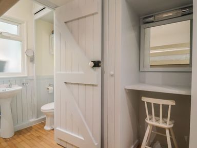 A bathroom with a sink, toilet, and mirror at Salt & Stone in Lyme Regis