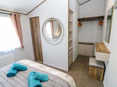 A bedroom with a bed and storage at Dukes Meadow in Carmarthen