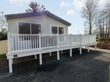 A house with a deck and railing at Dukes Meadow in Carmarthen