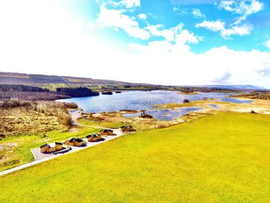 An outdoor area with cabins and a lake at No. 7 Enniskillen