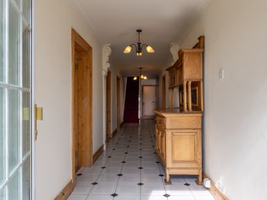A hallway with a sideboard and staircase at Ballyneill Farmhouse, Carrick-On-Suir, County Tipperary