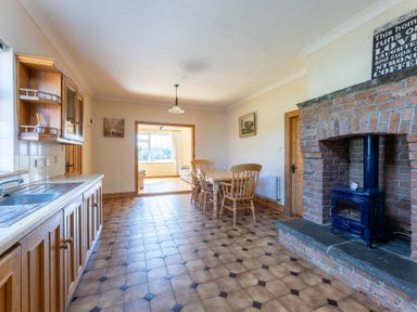 A kitchen with a dining area and wood stove at Ballyneill Farmhouse, Carrick-On-Suir, County Tipperary