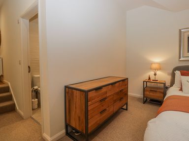 A bedroom with a dresser and side table at Ambwray in Ambleside