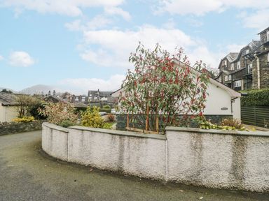 A property with trees and a wall at Ambwray in Ambleside
