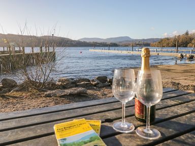 A table with glasses and champagne near the lake at Ambwray in Ambleside