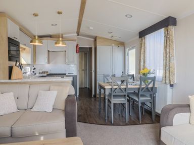 A living room with a sofa and dining area at Bordeaux in Ladram Bay Otterton