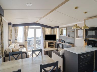 A living room with a sofa and dining table at Bordeaux in Ladram Bay Otterton