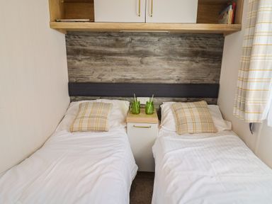 A bedroom with two beds and a bedside table at Bordeaux Ladram Bay Otterton