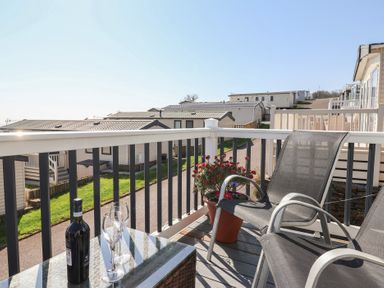 An outdoor area with a table, chairs and drinks at Bordeaux, Ladram Bay Otterton
