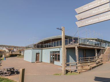A building with a terrace and seating area at The Three Rocks in Ladram Bay Otterton