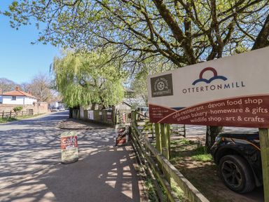 A road with a sign for Otterton Mill in Ladram Bay Otterton