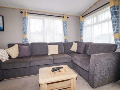 A living room with a grey sofa and a coffee table at Derwent L4 in Par