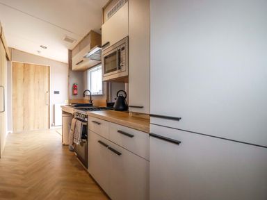 A kitchen with appliances and wooden cabinetry at Derwent L4 in Par