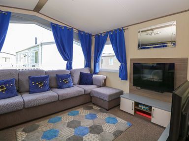 A living room with a sofa and television at PK Sunset View in Corton