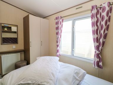 A bedroom with a bed and wardrobe at PK Sunset View in Corton