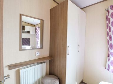 A bedroom with a mirror and cupboard at PK Sunset View in Corton