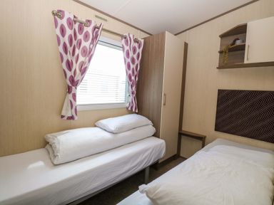 A bedroom with two beds and a wardrobe at PK Sunset View in Corton