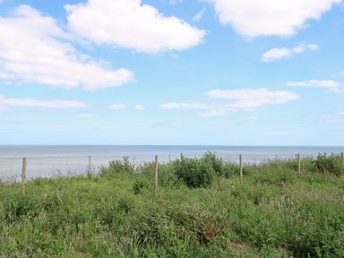 A coastal view of the sea and grass at PK Sunset View in Corton