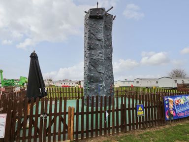 A rock climbing wall with a black umbrella in an outdoor area at PK Sunset View in Corton
