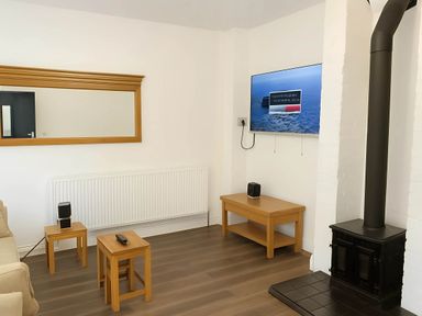 A living room with a mirror, television, and coffee table at Llangollen - House - Sleeps 8- Garden in Llangollen