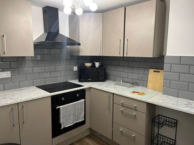 A kitchen with countertop, oven, microwave, and cabinets at Llangollen - House - Sleeps 8- Garden in Llangollen