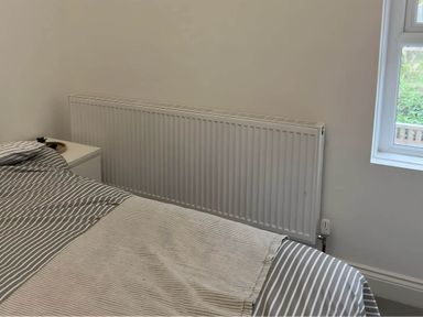 A bedroom with a bed and a radiator at Llangollen - House - Sleeps 8- Garden, Llangollen
