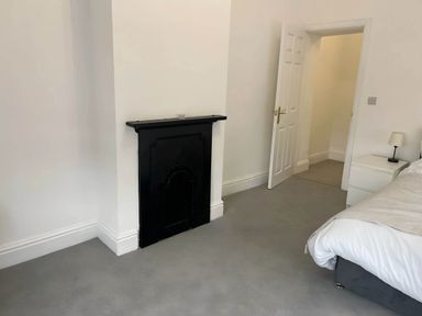 A bedroom with a fireplace and bed at Llangollen - House - Sleeps 8- Garden in Llangollen