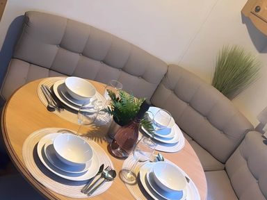 A dining table set with plates and glasses at Llanarmon-yn-Ial Mold 3-Bed Caravan, Sleeps 6 Llanarmon-Yn-Ial