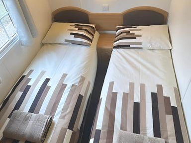 A bedroom with two single beds and a window at Llanarmon-yn-Ial Mold 3-Bed Caravan, Sleeps 6 Llanarmon-Yn-Ial