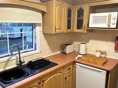 A kitchen with a sink, kettle, and microwave at Llanarmon-yn-Ial Mold 3-Bed Caravan, Sleeps 6 Llanarmon-Yn-Ial