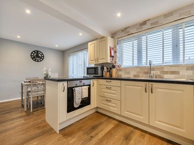 A kitchen with appliances and dining area at 2 Bed House - Sleeps 4 - Garden - Parking - Wifi, Kendal
