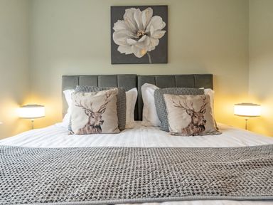 A bedroom with a bed and decorative pillows at 2 Bed House - Sleeps 4 - Garden - Parking - Wifi, Kendal
