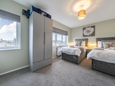 A bedroom with two beds and a wardrobe at 2 Bed House - Sleeps 4 - Garden - Parking - Wifi, Kendal