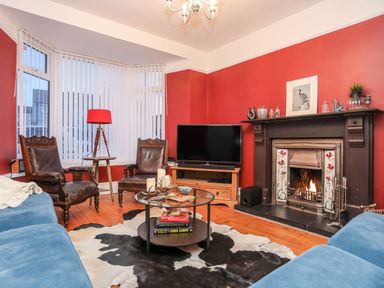 A living room with a fireplace and television at Rhiwlas in Rhosneigr