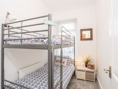 A bedroom with a bunk bed and a nightstand at Rhiwlas Rhosneigr