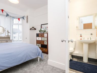 A bedroom with a bed and attached bathroom at Rhiwlas Rhosneigr
