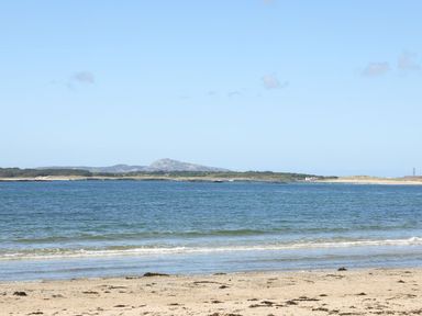 A beach with sand and water at Rhiwlas in Rhosneigr