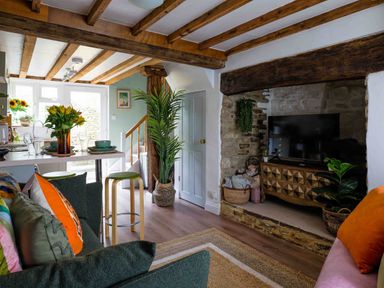 A living room with a sofa and television at Cotswolds Cozy Cottage Retreat - pet friendly, Finstock