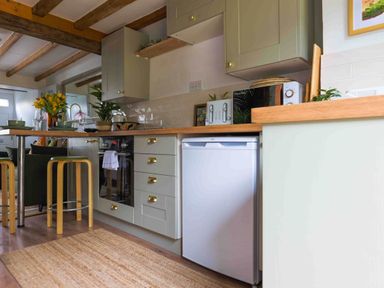 A kitchen with cabinets, stove, and refrigerator at Cotswolds Cozy Cottage Retreat - pet friendly, Finstock