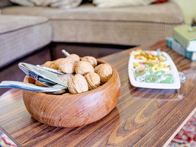 A wooden bowl with walnuts and a nutcracker in a living room at Family Country Cottage with a private Valley View