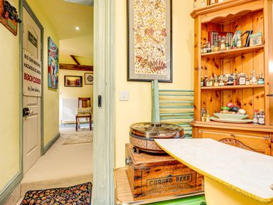 A kitchen with a wooden shelf and bottles at Family Country Cottage with a private Valley View
